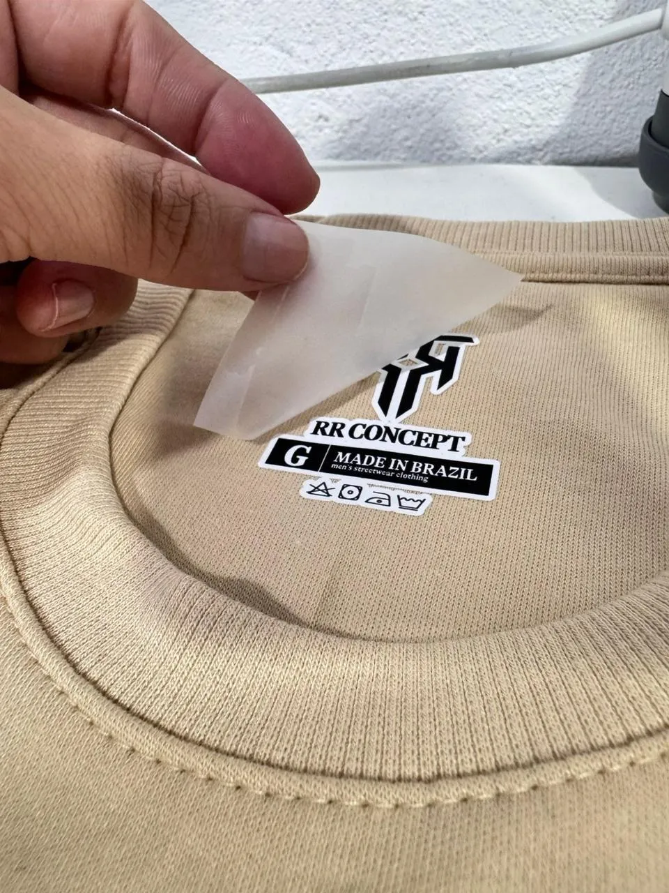 Etiqueta DTF sendo aplicada na gola de uma camiseta